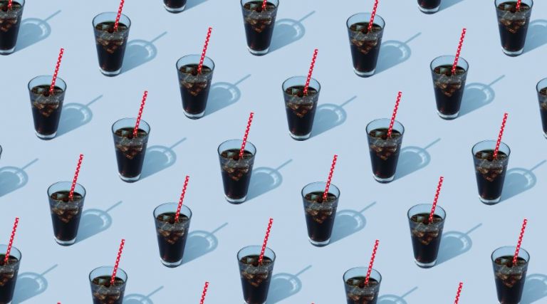 A pattern of a repeated image of a glass of soda with a red straw on a blue background.