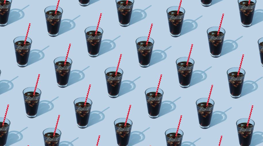 A pattern of a repeated image of a glass of soda with a red straw on a blue background.